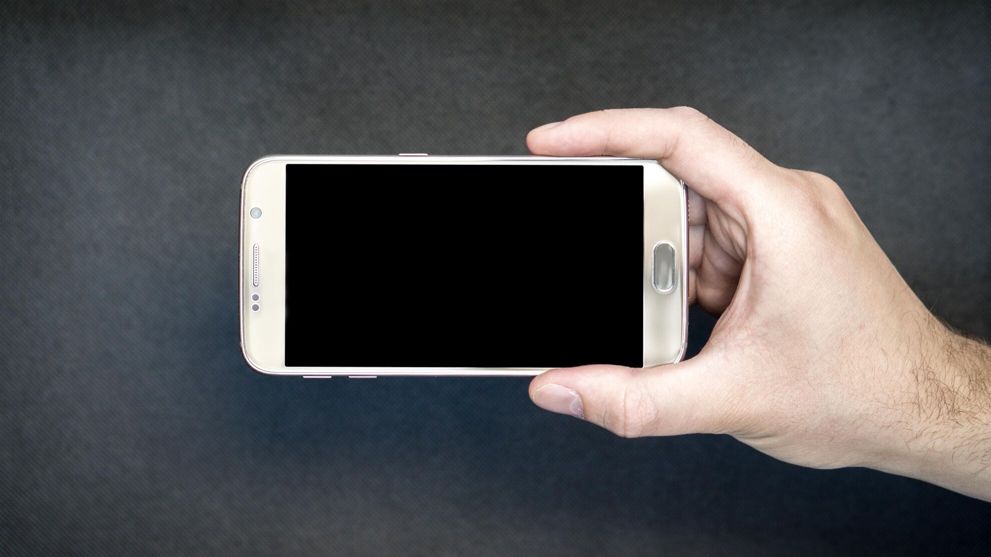 смартфон, мобильный телефон в руке человека на черном фоне - Raketanews.ru, 16.08.2023